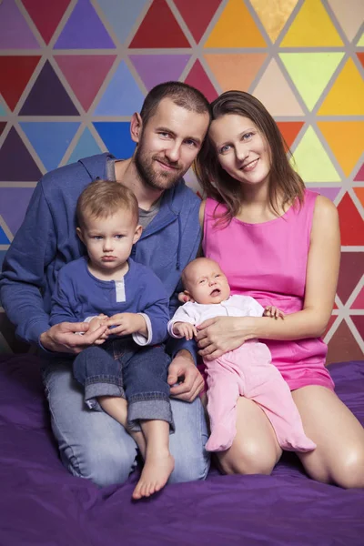 Linda familia ordinaria caucásica en ropa casual en casa sentado — Foto de Stock