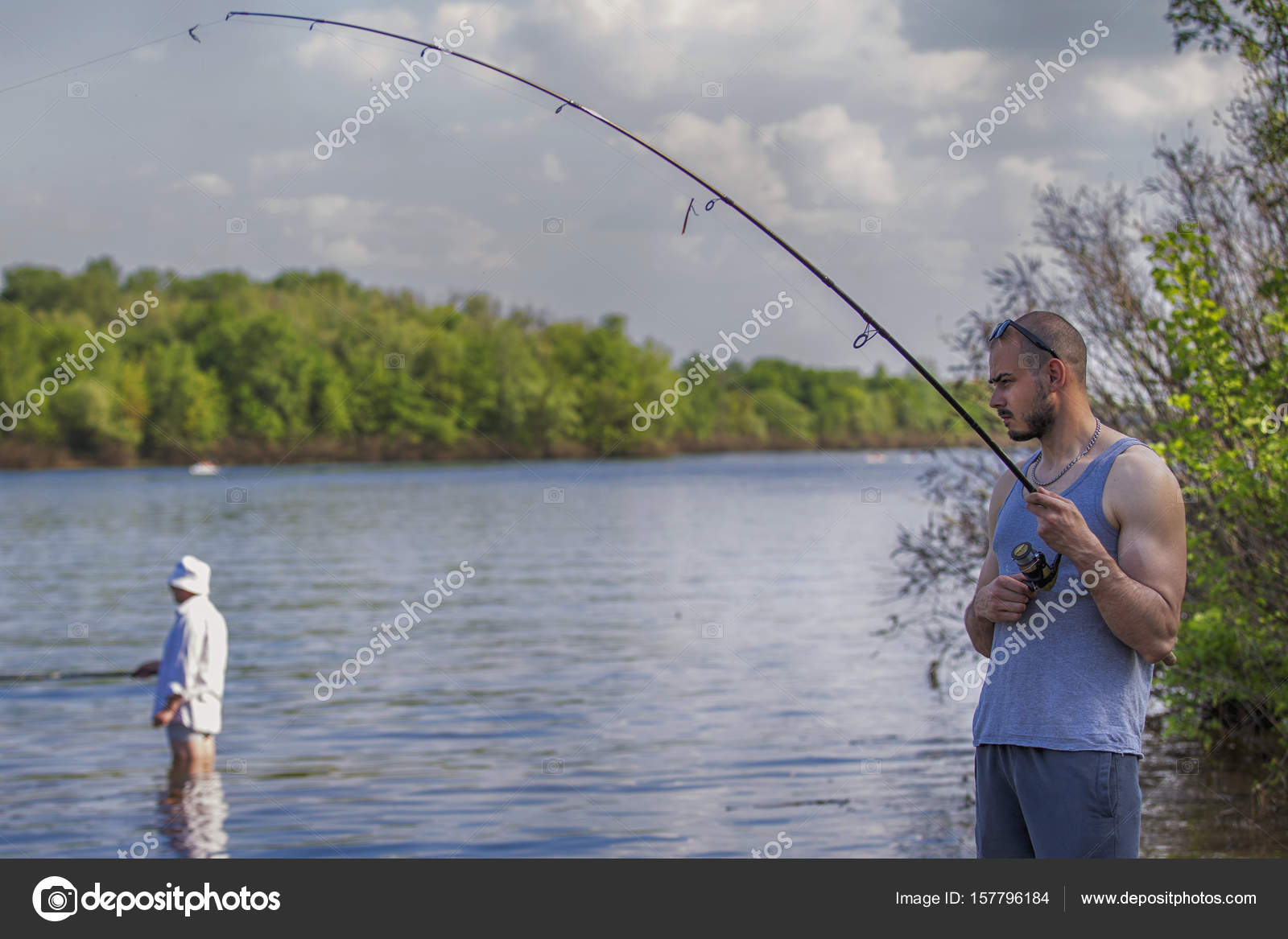 Young handsome brutal caucasian man in casual outfit fishing on Stock Photo  by ©Annademy 157796184