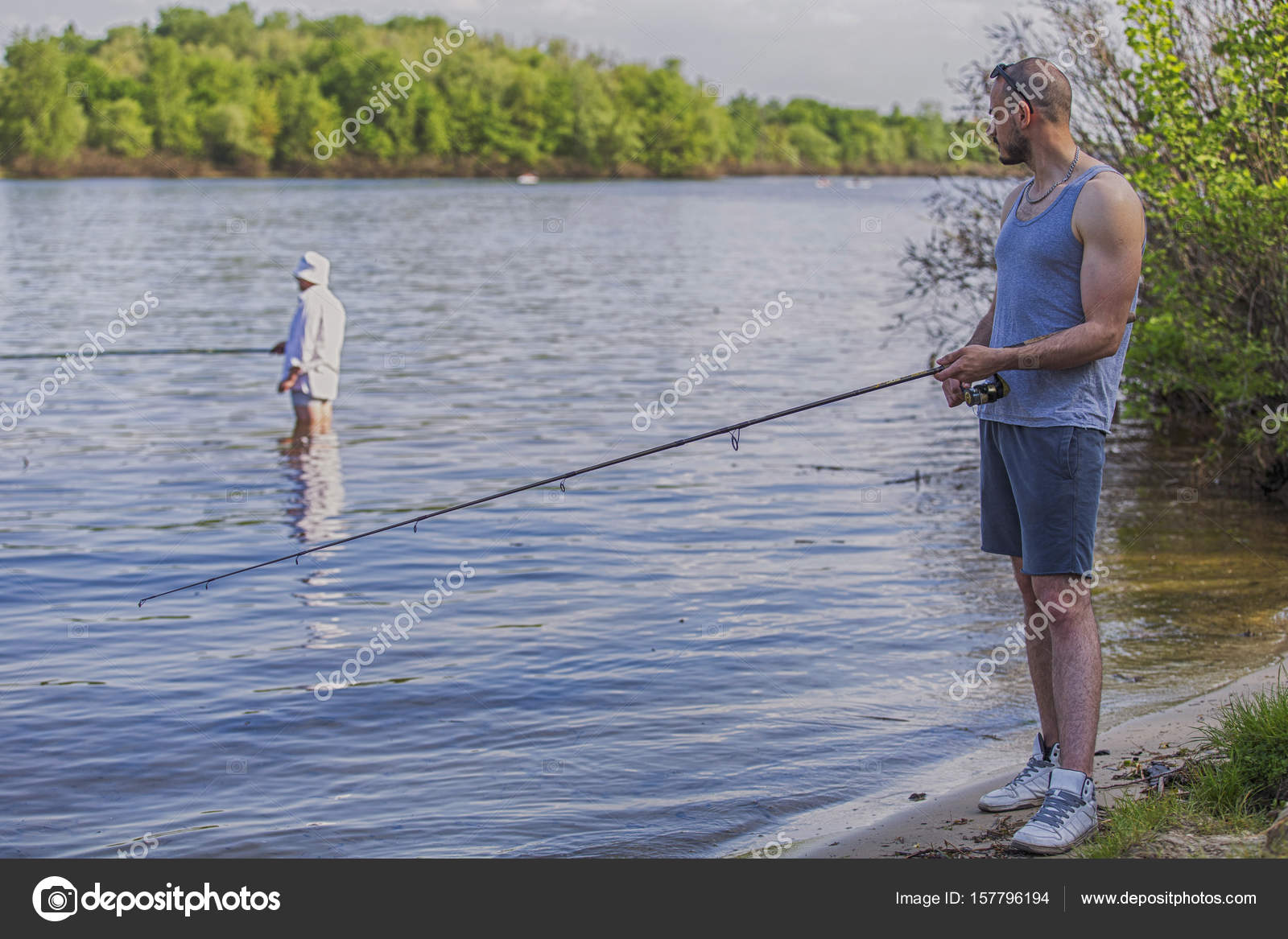 Young handsome brutal caucasian man in casual outfit fishing on Stock Photo  by ©Annademy 157796194