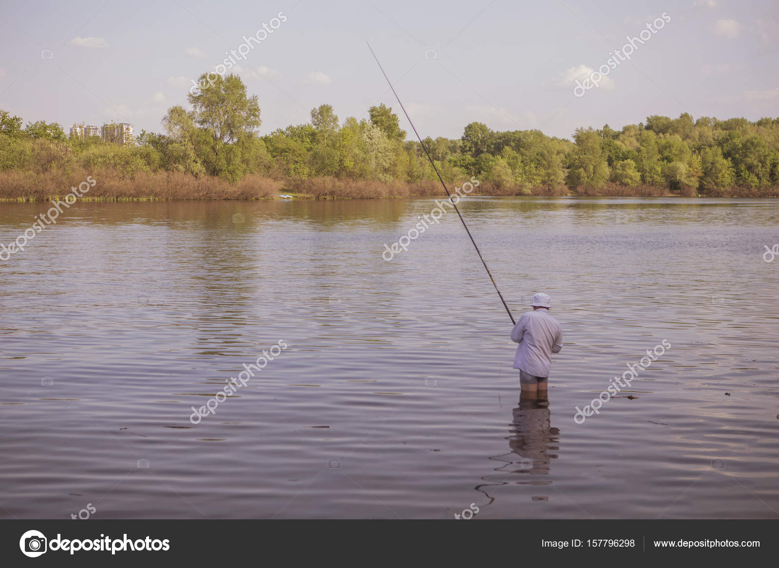 Young handsome brutal caucasian man in casual outfit fishing on