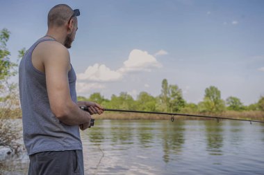 Genç yakışıklı acımasız beyaz adam rahat kıyafet balık üzerinde 