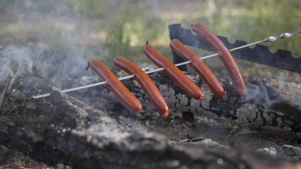 Ognisko z dymu i grill grilla jedzenie: kiełbaski dla sandw — Zdjęcie stockowe
