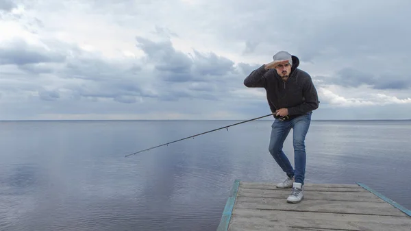 Ung snygg brutala kaukasiska man casual outfit fiske på — Stockfoto