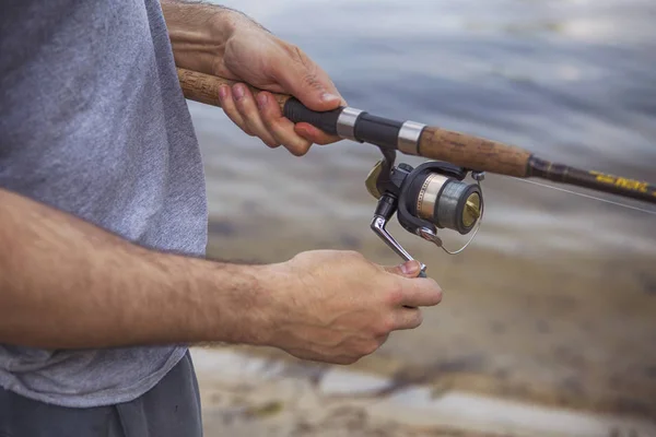 Young handsome brutal caucasian man in casual outfit fishing on — Stock Photo, Image