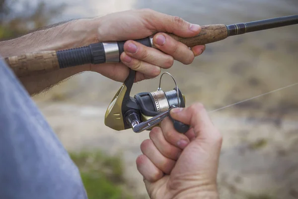 Young handsome brutal caucasian man in casual outfit fishing on