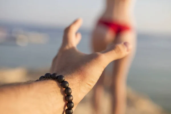 Hombre mano tratar de obtener mujer sexy culo (de pie detrás de él) en un r — Foto de Stock