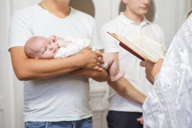 Küçük çocuk bap içinde tutarak vaftiz babası (beyaz genç adam)