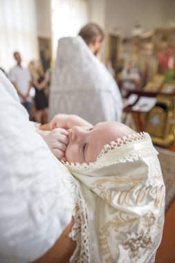 Küçük çocuk bap içinde tutarak vaftiz babası (beyaz genç adam)