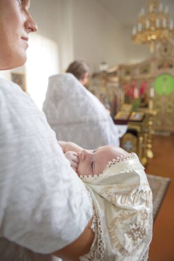 Küçük çocuk bap içinde tutarak vaftiz babası (beyaz genç adam)