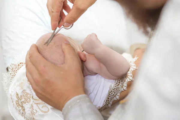 Abbe κοπής μαλλιά για ένα μικρό βρέφος παιδί σε βάπτιση (βαφτίσια — Φωτογραφία Αρχείου