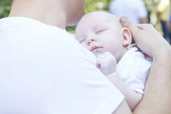 Feliz familia europea sonriendo al aire libre. Mamá y papá sosteniendo su —  Fotos de Stock