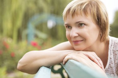 Yaşlı kadın onu serbest zaman Park'ta rahatlatıcı yürüyüş üzerinde yaşlı. Neşeyle gülümseyerek. Güneşli bir gün. Kopya alanı