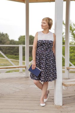 Yaşlı kadın onu serbest zaman Park'ta rahatlatıcı yürüyüş üzerinde yaşlı. Neşeyle gülümseyerek. Güneşli bir gün. Kopya alanı