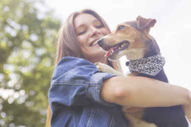 Sevimli güzel ince beyaz esmer kadın gündelik kıyafeti (etek, tişört ve kot ceket) yaz günü çok güzel onunla parkta bir yürüyüş jack russell köpek. Onlar dolu sevinç, gülümseyen ve eğlenin