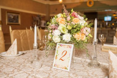 Masa dekor düğün gül ve eustoma çiçekler, mumlar ve şeftali dolu kumaş renkli. Lüks zengin Restoran iç. Kapalı. Kopya alanı