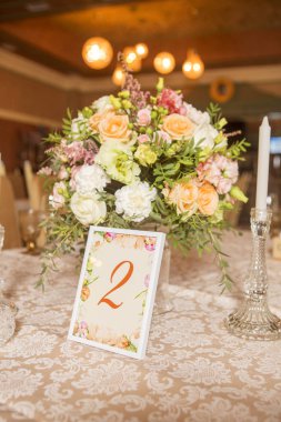 Masa dekor düğün gül ve eustoma çiçekler, mumlar ve şeftali dolu kumaş renkli. Lüks zengin Restoran iç. Kapalı. Kopya alanı