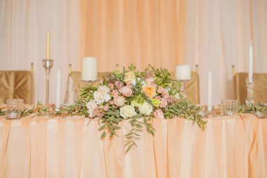 Masa dekor düğün gül ve eustoma çiçekler, mumlar ve şeftali dolu kumaş renkli. Lüks zengin Restoran iç. Kapalı. Kopya alanı