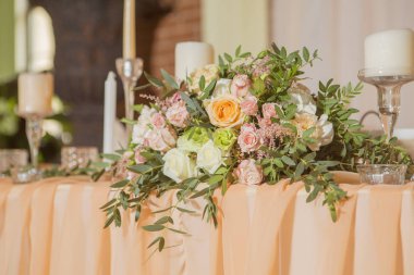 Masa dekor düğün gül ve eustoma çiçekler, mumlar ve şeftali dolu kumaş renkli. Lüks zengin Restoran iç. Kapalı. Kopya alanı