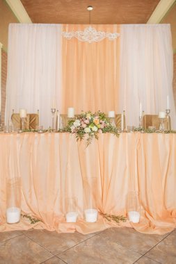 Masa dekor düğün gül ve eustoma çiçekler, mumlar ve şeftali dolu kumaş renkli. Lüks zengin Restoran iç. Kapalı. Kopya alanı