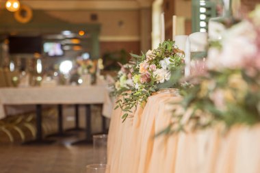 Masa dekor düğün gül ve eustoma çiçekler, mumlar ve şeftali dolu kumaş renkli. Lüks zengin Restoran iç. Kapalı. Kopya alanı