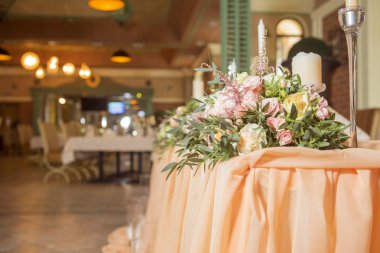 Masa dekor düğün gül ve eustoma çiçekler, mumlar ve şeftali dolu kumaş renkli. Lüks zengin Restoran iç. Kapalı. Kopya alanı