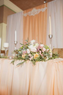 Masa dekor düğün gül ve eustoma çiçekler, mumlar ve şeftali dolu kumaş renkli. Lüks zengin Restoran iç. Kapalı. Kopya alanı