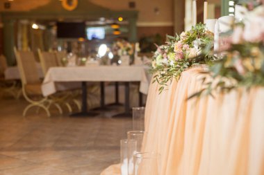 Masa dekor düğün gül ve eustoma çiçekler, mumlar ve şeftali dolu kumaş renkli. Lüks zengin Restoran iç. Kapalı. Kopya alanı