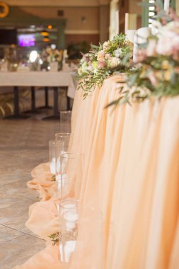 Masa dekor düğün gül ve eustoma çiçekler, mumlar ve şeftali dolu kumaş renkli. Lüks zengin Restoran iç. Kapalı. Kopya alanı