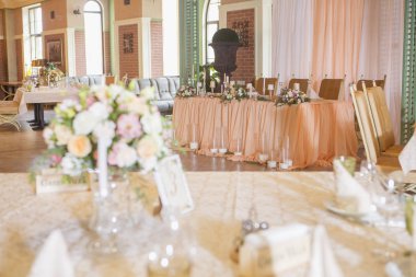 Masa dekor düğün gül ve eustoma çiçekler, mumlar ve şeftali dolu kumaş renkli. Lüks zengin Restoran iç. Kapalı. Kopya alanı