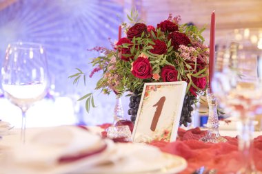 Bir düğün masaya şarap çiçek kümesi plakaları tarafından çevrili, sekme