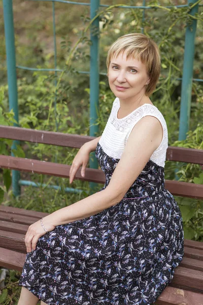 Старша літня жінка у вільний час ходить, відпочиваючи в парку. Посміхаючись весело. Сонячний день. Копіювати простір — стокове фото