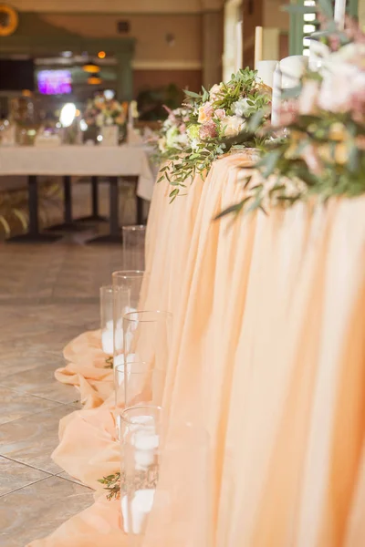 Masa dekor düğün gül ve eustoma çiçekler, mumlar ve şeftali dolu kumaş renkli. Lüks zengin Restoran iç. Kapalı. Kopya alanı
