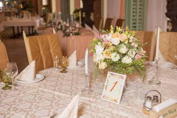 Masa dekor düğün gül ve eustoma çiçekler, mumlar ve şeftali dolu kumaş renkli. Lüks zengin Restoran iç. Kapalı. Kopya alanı