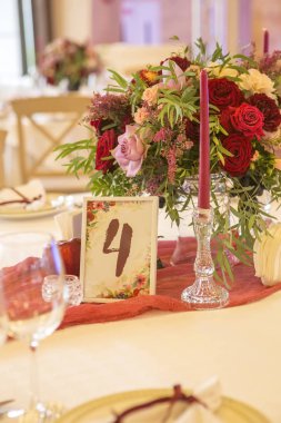 Şarap çiçekleri tabaklar, masa örtüleri ve mumlar çevrili bir düğün tablo ayarlama. İç. Kopya alanı