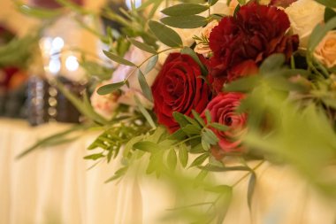 Tabaklar, masa örtüleri ve mumlar çevrili bir düğün masaya şarap renkli çiçek. İç. Kopya alanı