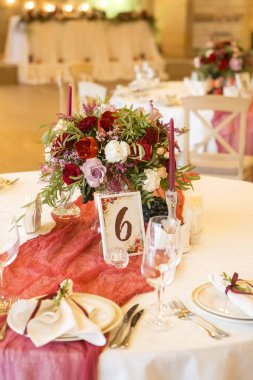 Şarap çiçekleri tabaklar, masa örtüleri ve mumlar çevrili bir düğün tablo ayarlama. İç. Kopya alanı