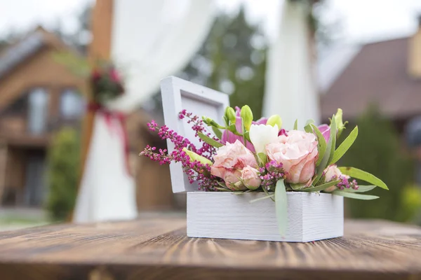 Wedding box for rings with wine color flowers and ribbon on a gr