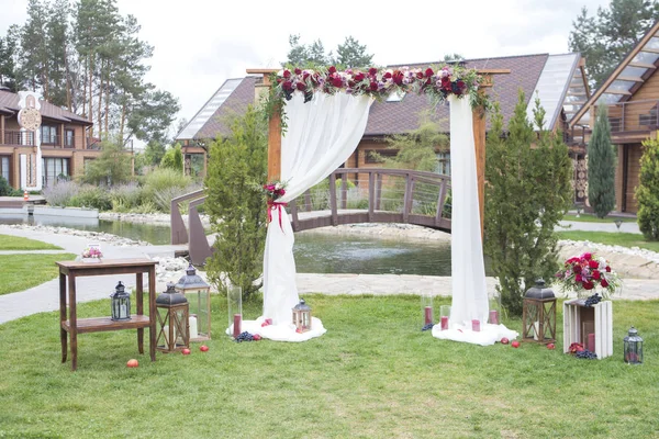 Flores de cor de vinho em um arco de casamento com tecido de tule e woode — Fotografia de Stock