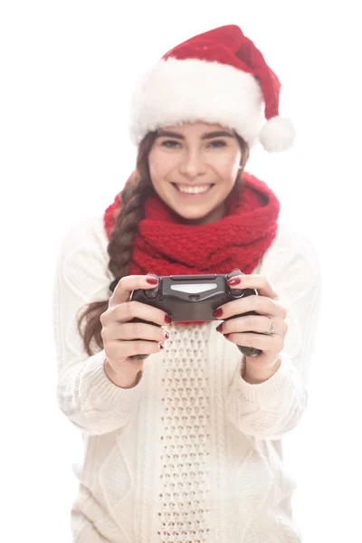 可爱的十几岁的女孩 长着深色头发 白色的毛衣和红色的圣诞老人帽子 她使用控制台操纵杆 情感生活肖像 — 图库照片