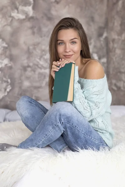 젊은 아름 다운 백인 여자는 침대에 앉아 책을 읽고. — 스톡 사진