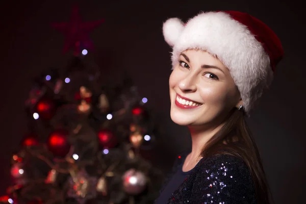 Niedlich Lächelnde Frau Mit Weihnachtsmütze Und Abendkleid Der Nähe Des — Stockfoto