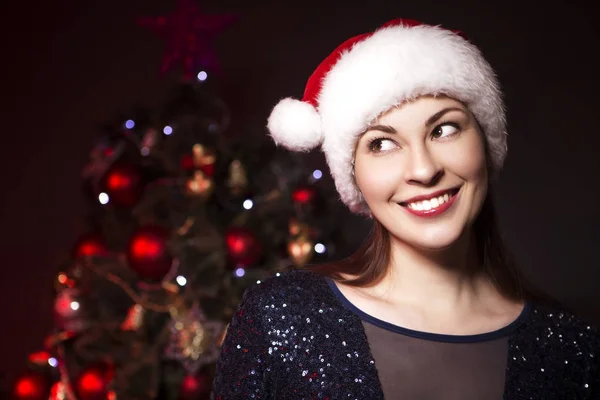 Niedlich Lächelnde Frau Mit Weihnachtsmütze Und Abendkleid Der Nähe Des — Stockfoto