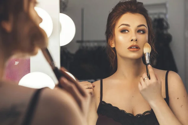 Mujer morena aplicando maquillaje (pintar su piel) para una noche d —  Fotos de Stock