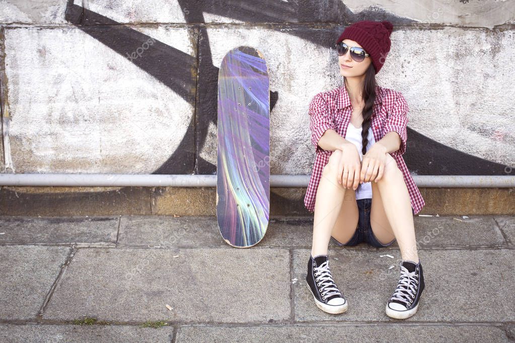 Brunette teenage girl in hipster outfit (jeans shorts, keds, pla