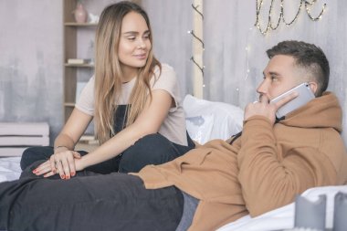 Şık hipster çift erkek ve kadın yatakta oturup... onların 