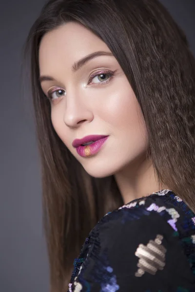 Caucasian brunette woman with creative make up (sequins and glit