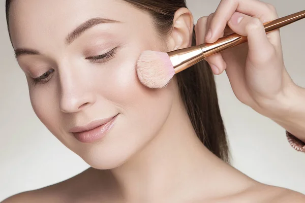 Make up artist preparing beautiful brunette caucasian young woma