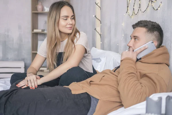 Elegante coppia hipster di uomo e donna seduti sul letto nel loro — Foto Stock