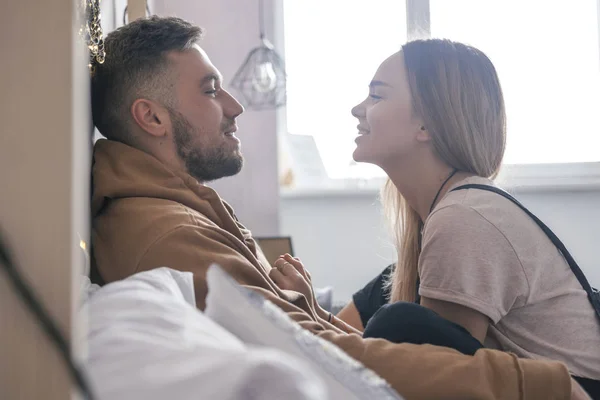 Elegante coppia hipster di uomo e donna seduti sul letto nel loro — Foto Stock