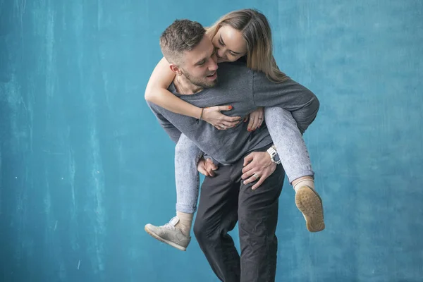 Elegante souple hipster in abbigliamento casual accogliente in piedi vicino al blu — Foto Stock